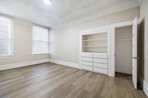 A room with a white door and a window with blinds.