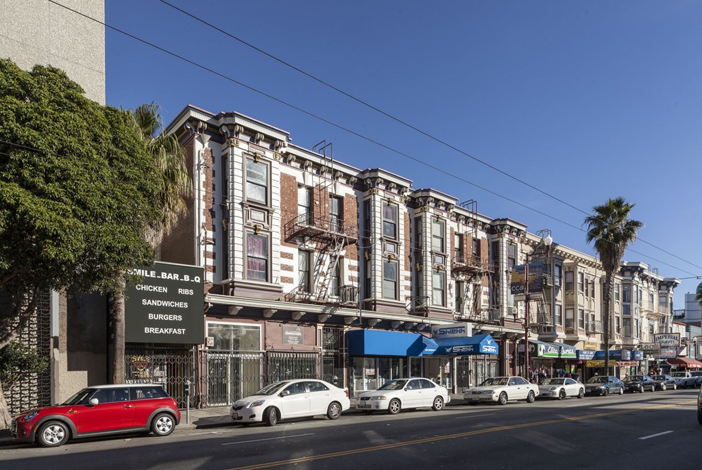 A row of old buildings with a sign that says Sandwiches and Breakfast.