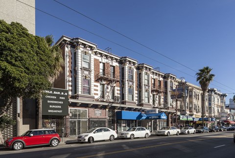 A row of old buildings with a sign that says Sandwiches and Breakfast.