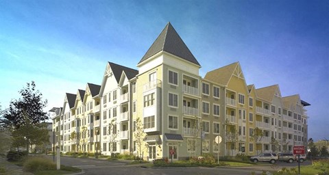 A large, modern apartment building with a mix of beige and white exterior colors.