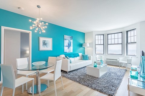 a living room with a blue accent wall and a white couch
