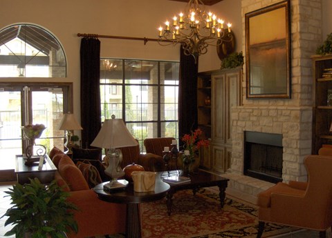 a living room with a stone fireplace and furniture
