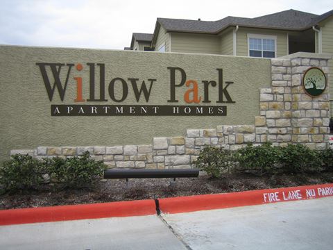 a sign for willow park apartment homes is shown in front of a stone wall