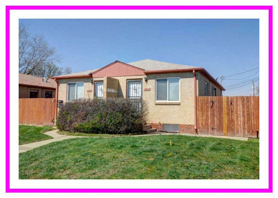 a yellow house with a yard and a wooden fence