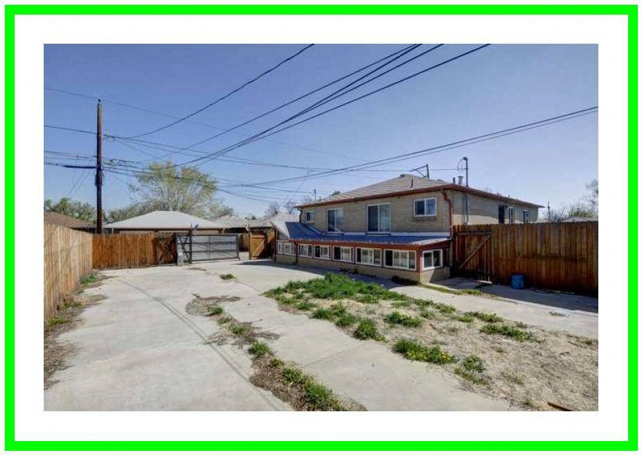 an empty yard with a house and a fence