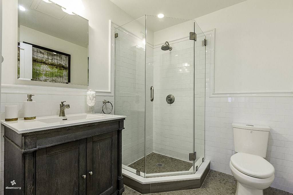 a white bathroom with a shower and a sink and a toilet