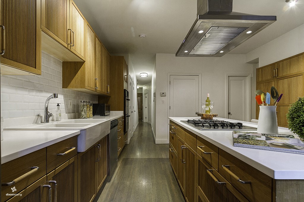 a kitchen with wooden cabinets and white counter tops