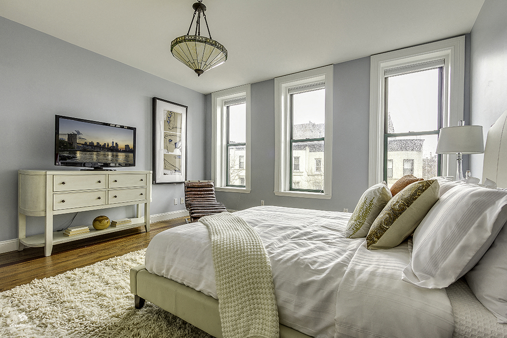 a bedroom with a large bed and a tv