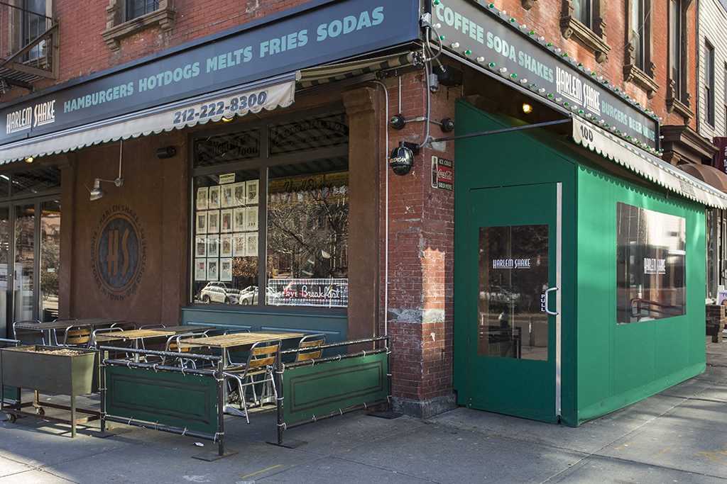 the front of a restaurant with tables and chairs outside