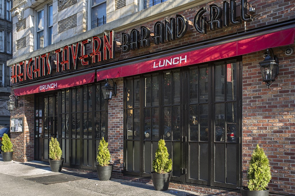 the exterior of a restaurant with large windows and a red awning