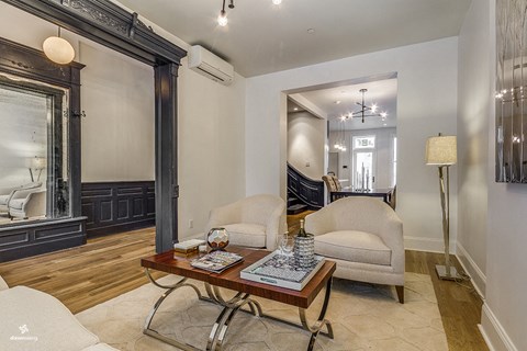 A living room with a wooden floor and a white sofa.