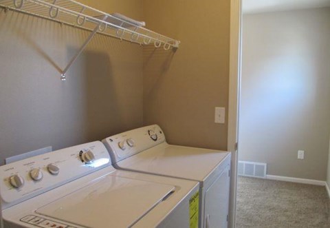 an empty laundry room with a white washer and dryer