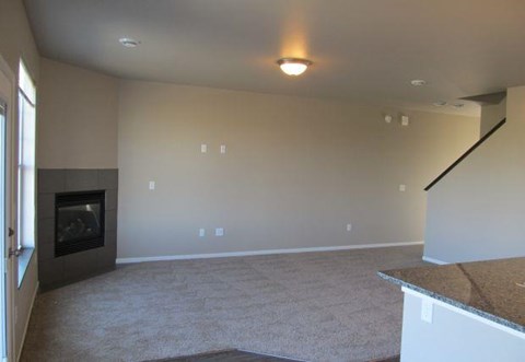an empty living room with a fireplace