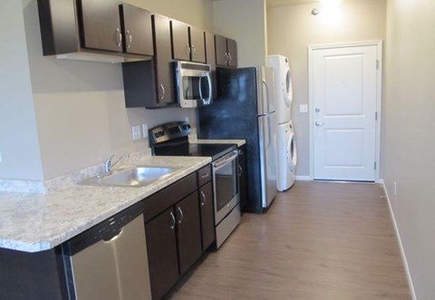 a kitchen with a stove refrigerator and a sink
