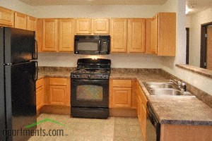 a kitchen with wooden cabinets and black appliances