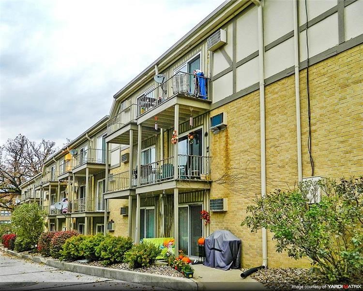 a yellow brick apartment building with balconies
