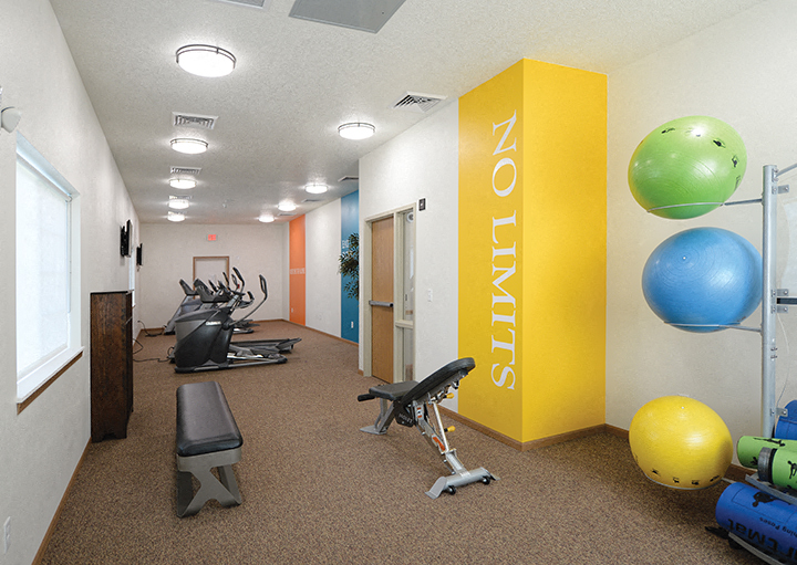 A gym with a yellow wall and a sign that says "NOUNS" on it.