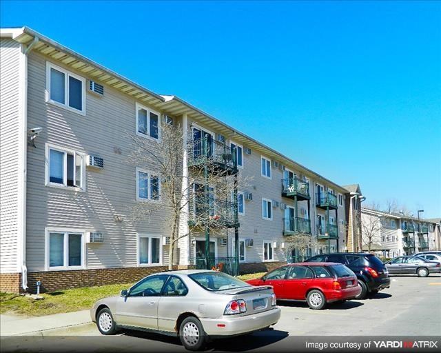a row of cars parked in front of an apartment building