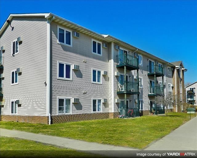an apartment building with balconies on the side of a sidewalk