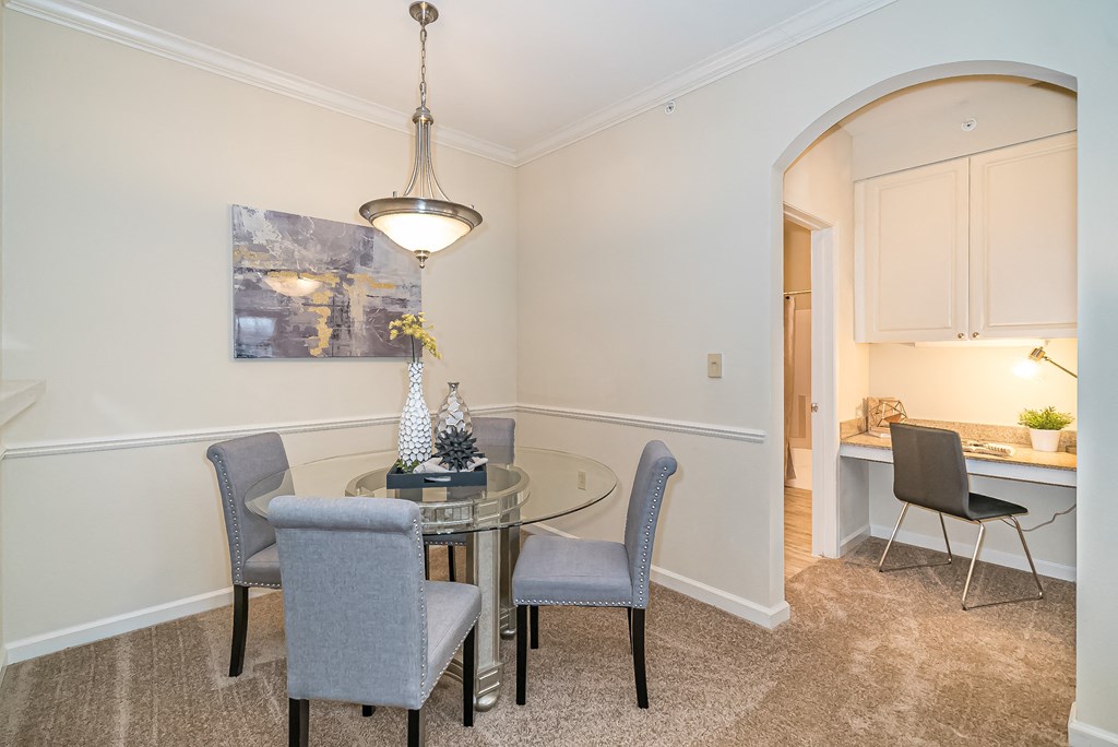 a dining room with a glass table and chairs