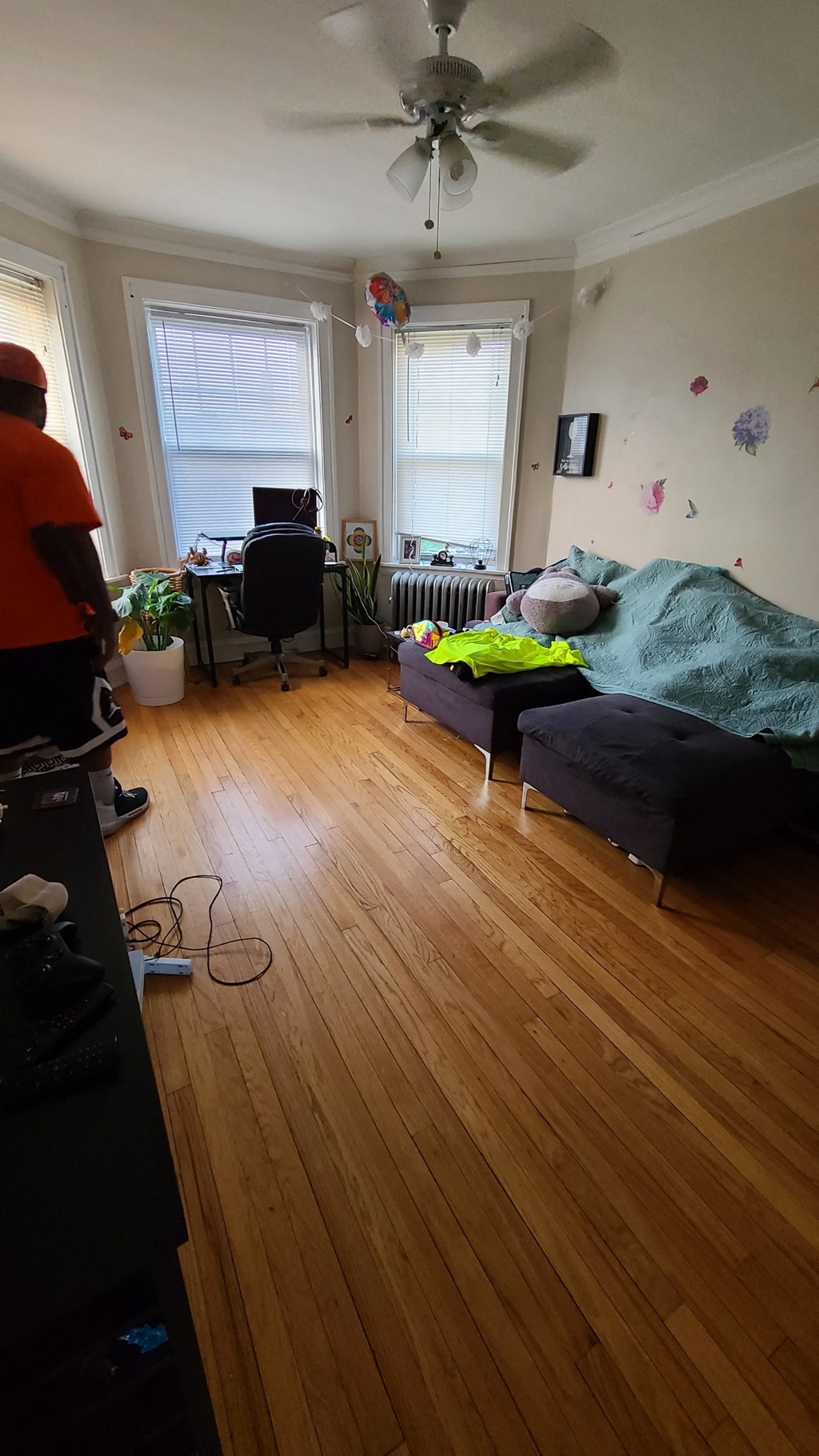 a living room with a bed and a ceiling fan