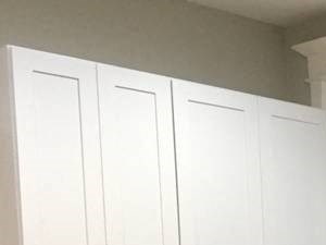 A kitchen with white cabinets and wooden floors.