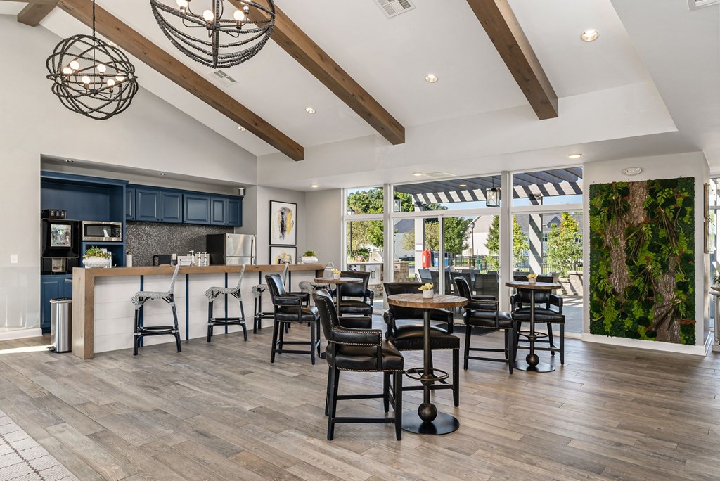 a living room with a kitchen and a dining room with tables and chairs