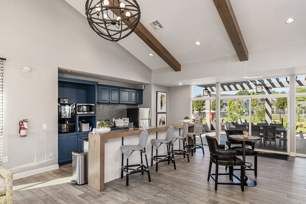 a kitchen with a bar and a dining area with chairs