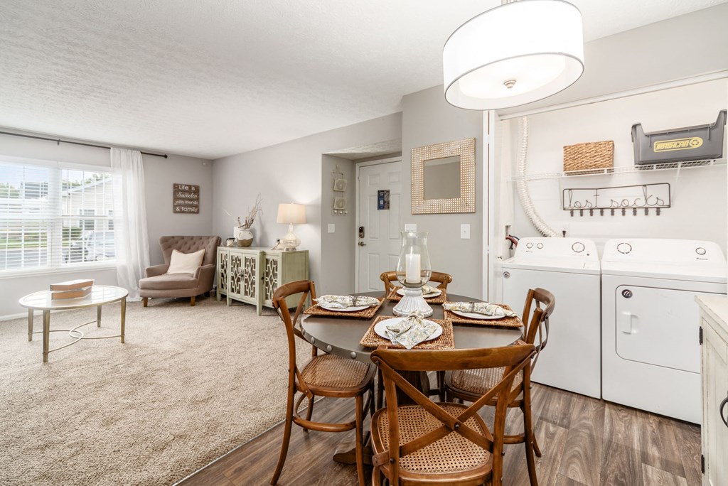 A dining room with a wooden table set for two.