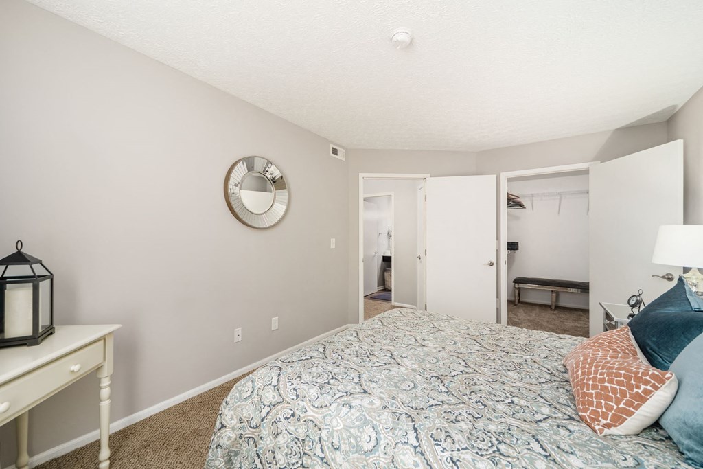 a bedroom with a large bed and a mirror