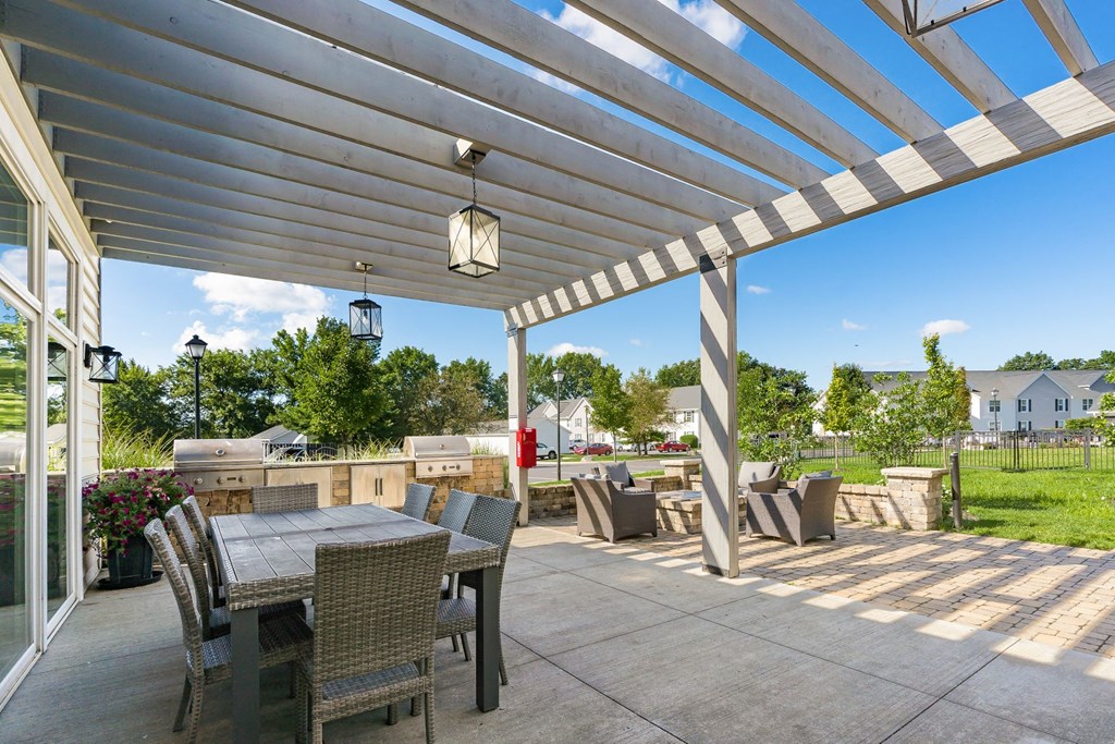 a patio with a table and chairs under a white roof