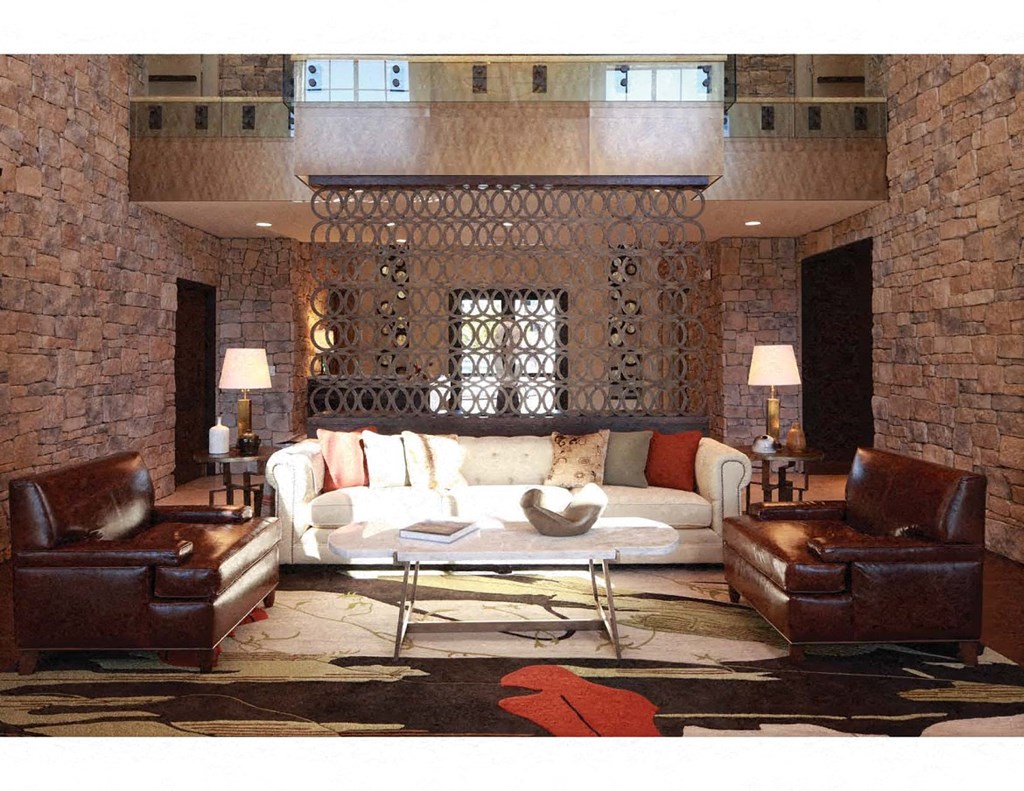 a living room with a white couch and leather furniture