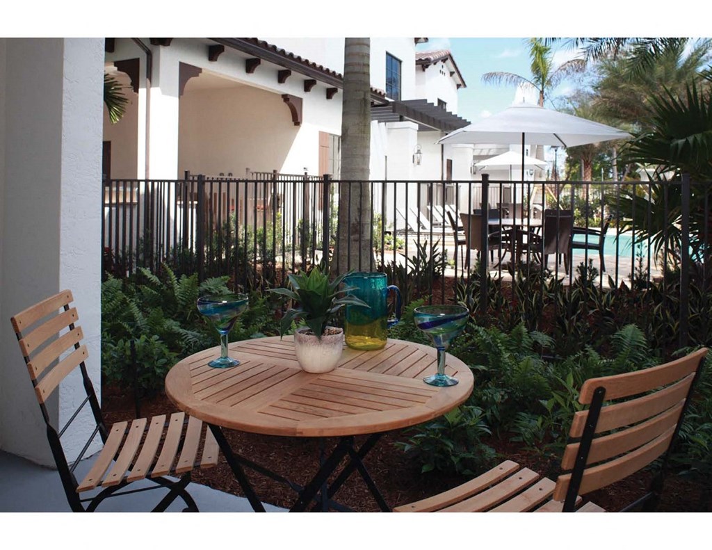 a patio with a table and chairs next to a pool