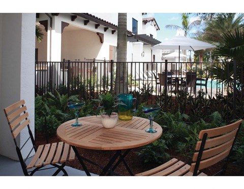 a patio with a table and chairs next to a pool