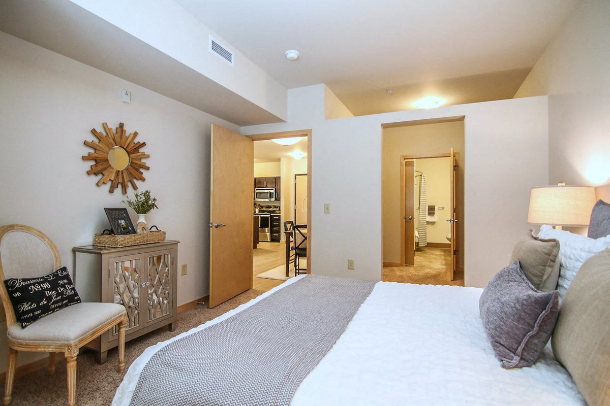 a bedroom with a large bed and a door to a bathroom