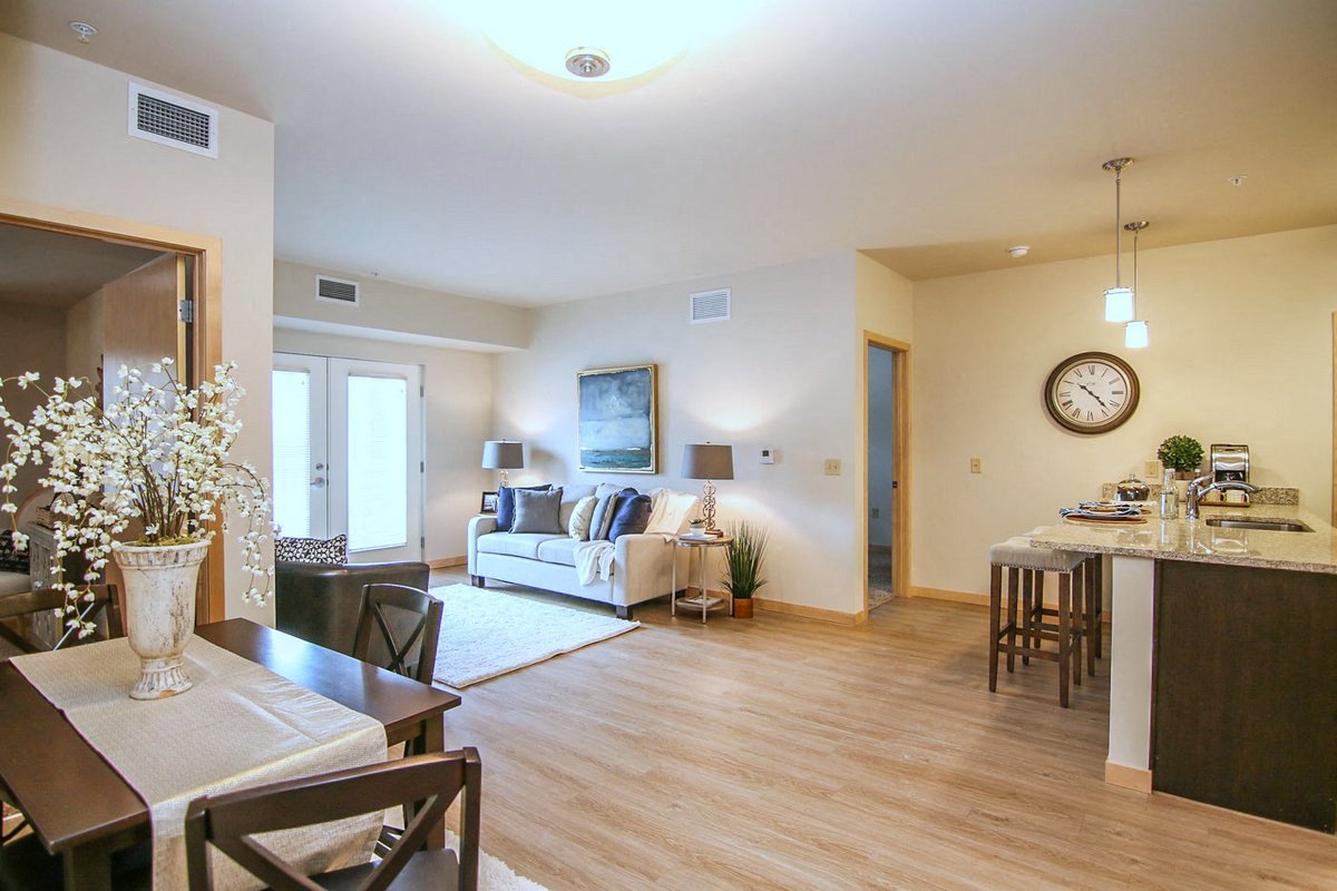a living room and dining room with a clock on the wall