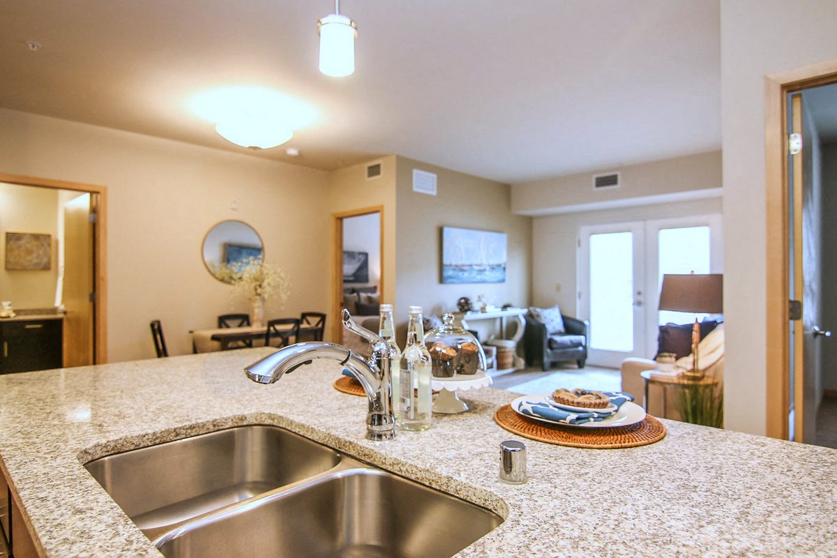 a kitchen with a sink and a view of a living room