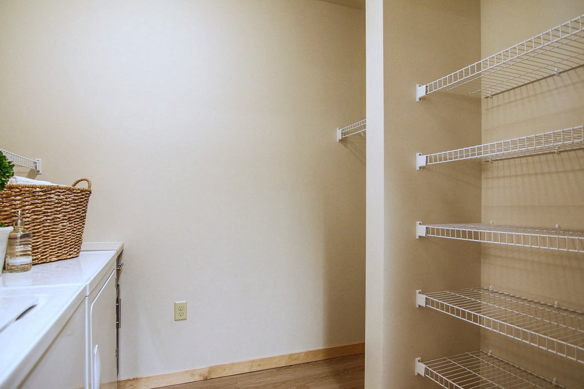 a walk in closet with wire shelves and a sink