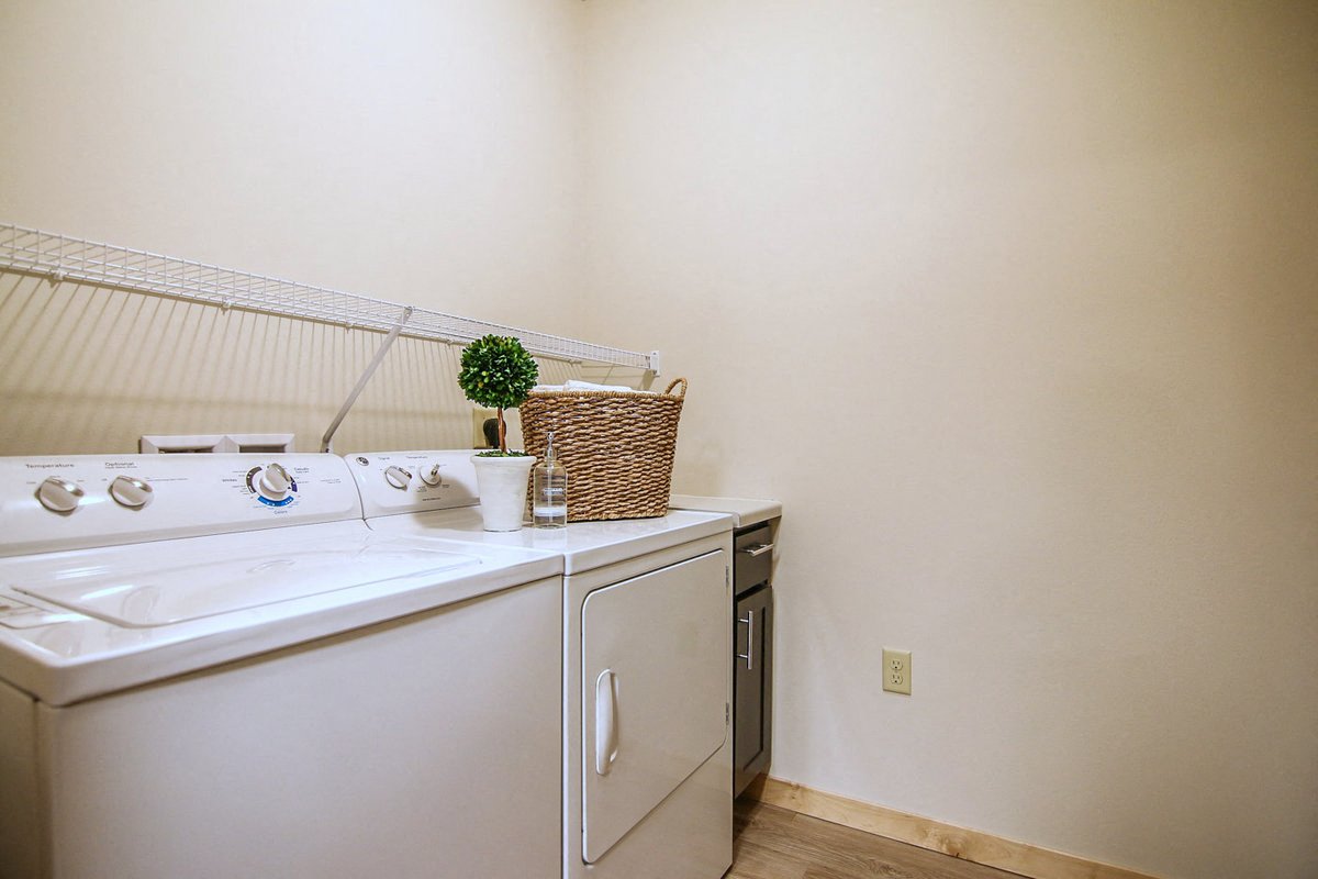 a washer and dryer in a laundry room with a basket on top