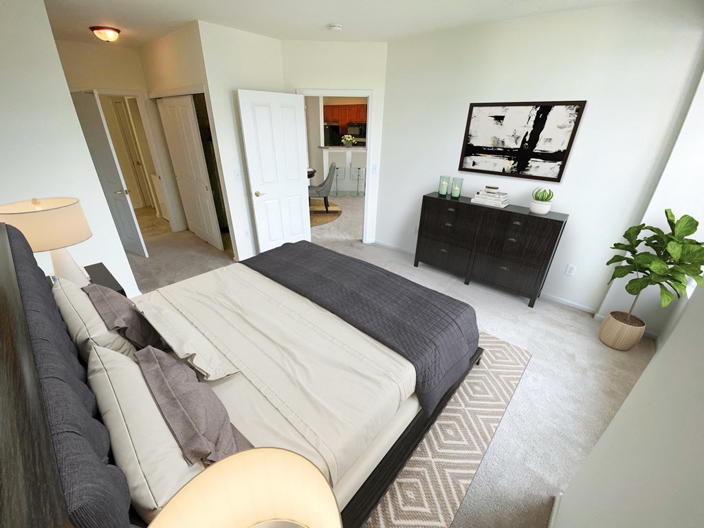 a bedroom with a bed and a dresser and a bathroom