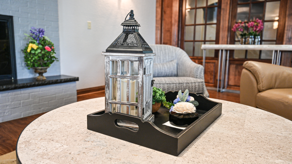 a table centerpiece with a lantern and a cupcake on it