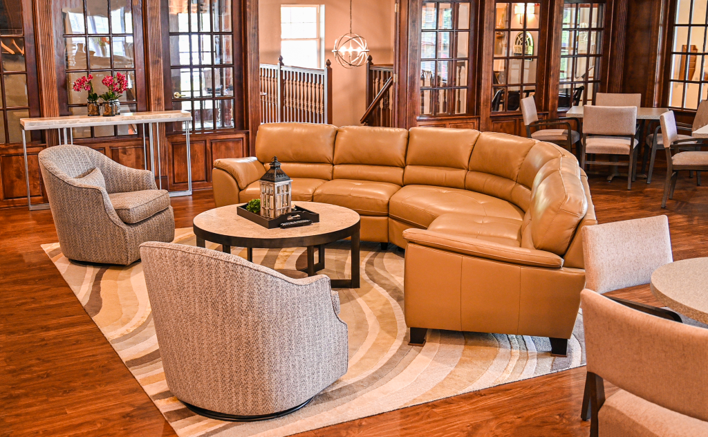 a living room with a brown leather couch and chairs