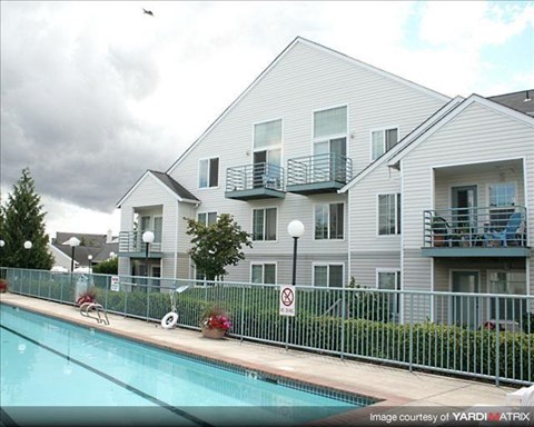A pool in front of a building with a no swimming sign.
