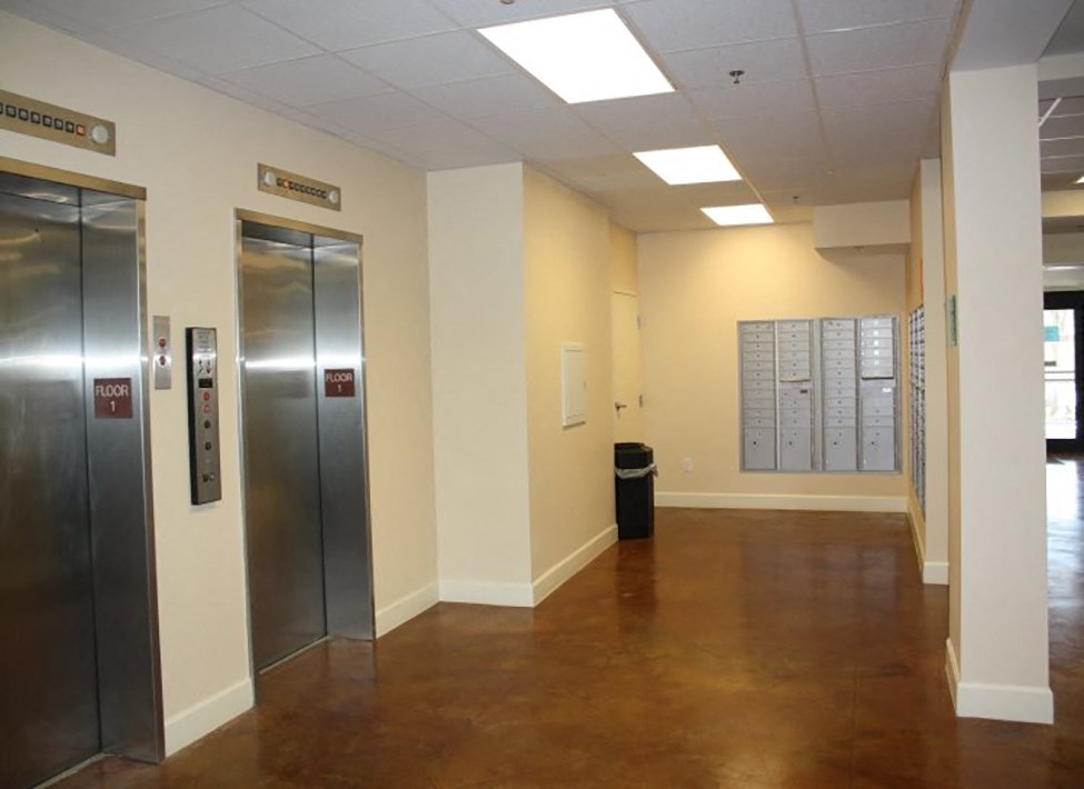 an empty hallway with elevators and doors in a building