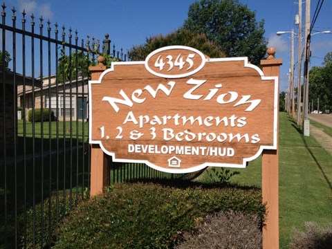 A sign for New Zion Apartments with 1, 2, and 3 bedrooms.
