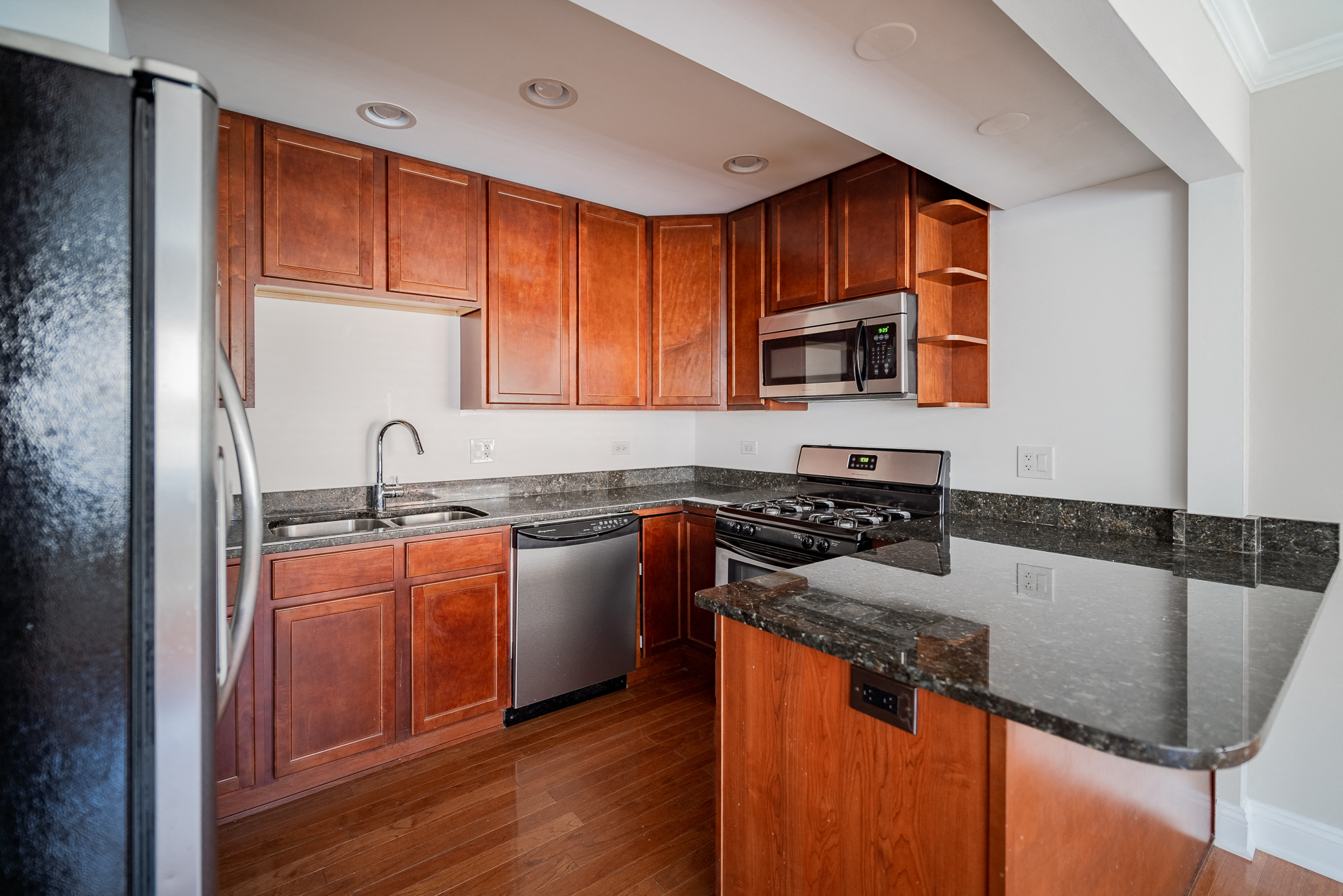 a kitchen with wooden cabinets and granite counter tops and stainless steel appliances