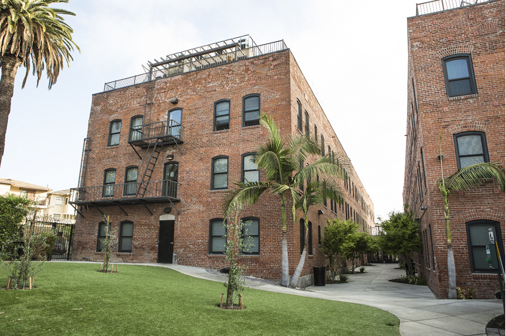 a red brick building with palm trees in front of it