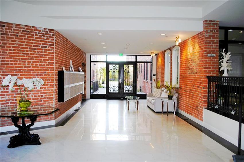 a living room with a brick wall and a white floor