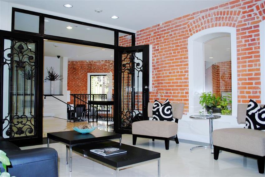 a living room with furniture and a brick wall