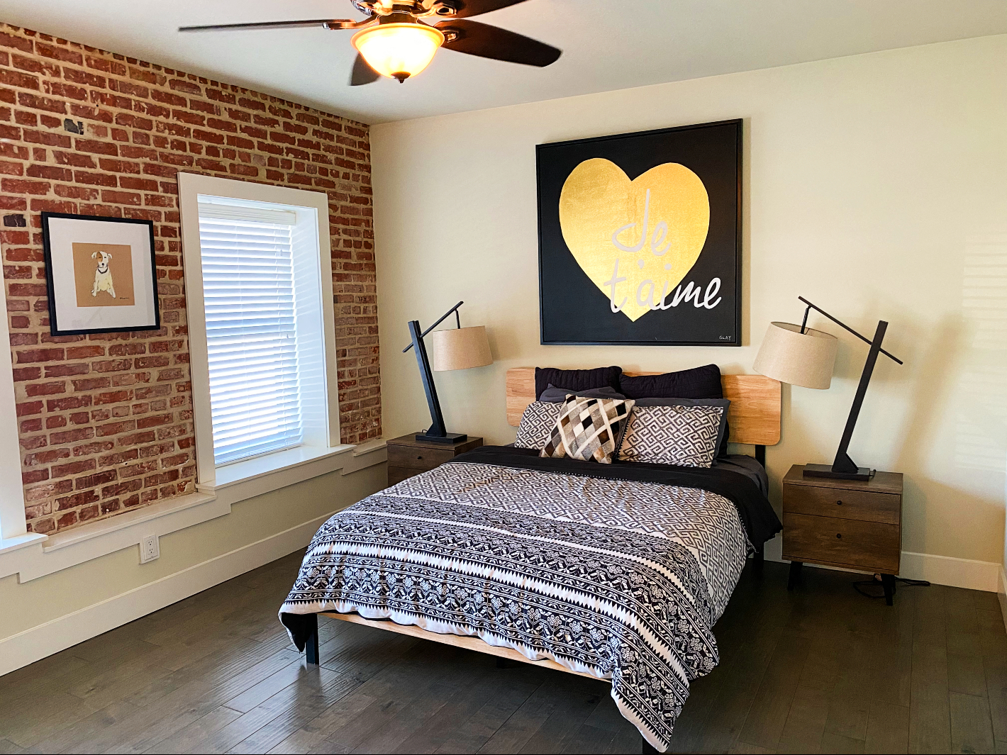 a bedroom with a bed and a painting of a heart on the wall